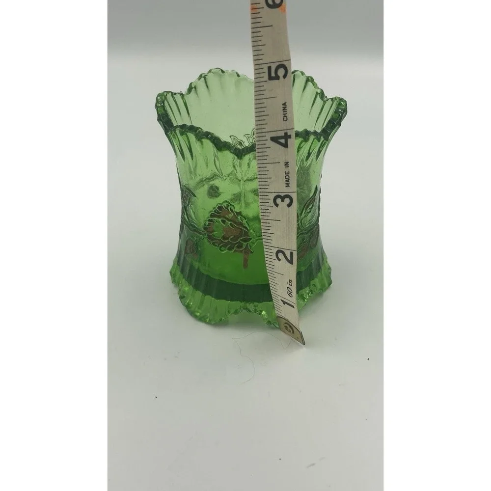An Antique EAPG green glass spoon holder with gold floral overlay.